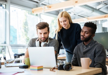 happy-colleagues-sitting-in-office-coworking-PHYA6TG